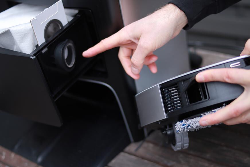 The compartment with the dust bag of the Ecovacs Deebot X1 Station can be seen in the close-up view. 